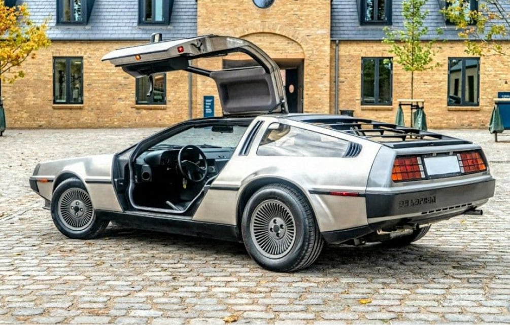 DeLorean DMC-12 с открытыми дверями Gullwing на мощёной улице