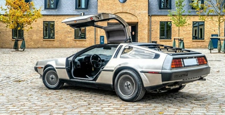 DeLorean DMC-12 с открытыми дверями Gullwing на мощёной улице